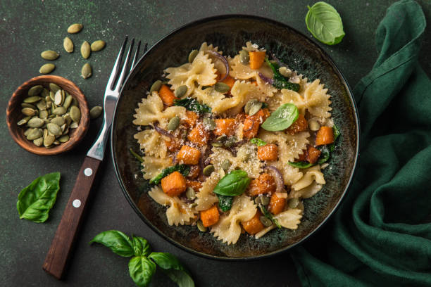 pumpkin farfalle pasta with pumpkin seeds and cheese in bowl - butternut squash roasted squash cooked imagens e fotografias de stock