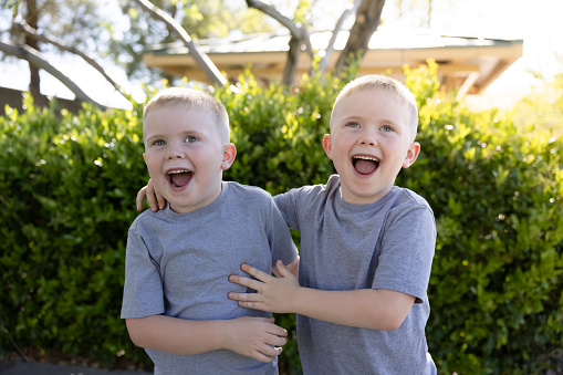 Identical twin boys at the park outside.