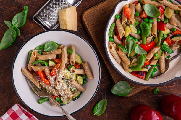 istock whole grain penne pasta with grilled vegetables ( zucchini, peas, bell pepper ant tomato) and cheese on pan 1314457243