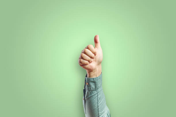 Man arm making ok gesture with hand isolated on green background stock photo