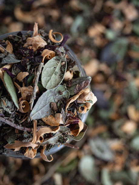 istock Organic herbal tea in a glass jar with dried herbs scattered around on a white background 1314458565