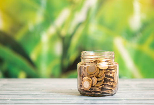 istock Coin in glass bottle with money stack 1314459374