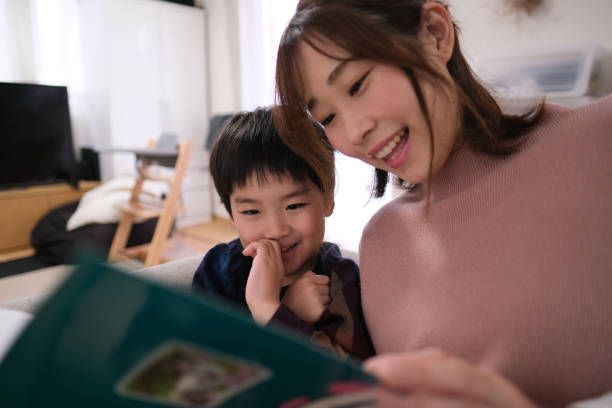 istock Child reading book with mother at home 1314461756