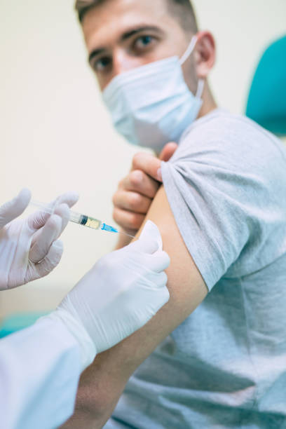 istock Covid-19 or coronavirus vaccine doctor holding syringe and using cotton before making injection to the patient in the medical mask. 1314462190