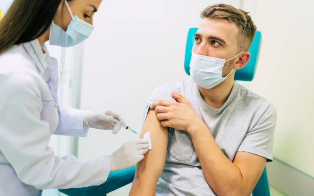 istock Covid-19 or coronavirus vaccine doctor holding syringe and using cotton before making injection to the patient in the medical mask. 1314462226