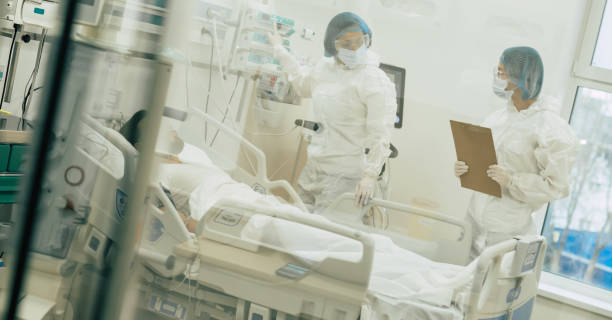 istock Doctors in protective suits and masks are examining the infected coronavirus young man patient in the hospital ward 1314462437
