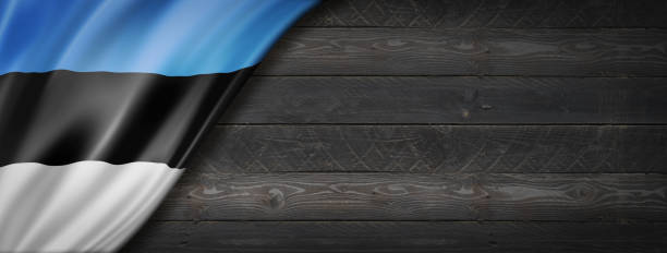 Estonia flag on black wood wall. Horizontal panoramic banner.