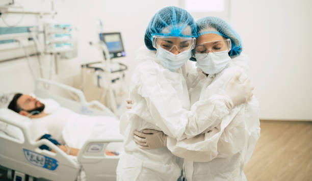 istock Two confident doctors in protective safety suits standing on background of a patient with coronavirus 1314463206