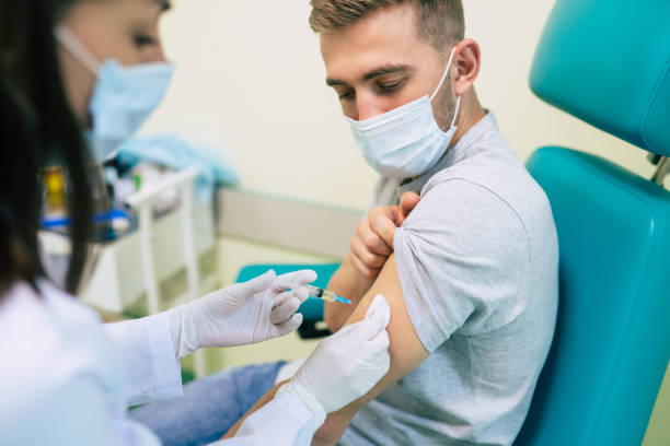 istock Covid-19 or coronavirus vaccine doctor holding syringe and using cotton before making injection to the patient in the medical mask. 1314463471