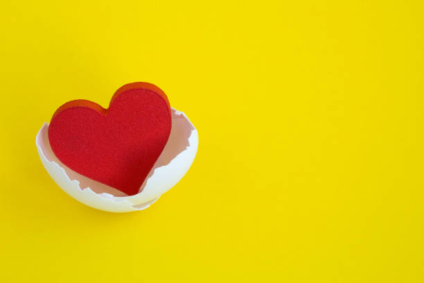 istock Red heart in the white eggshell on the yellow background 1314463555