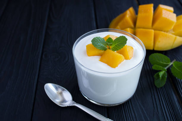 istock Milk yogurt with mango on the black wooden background 1314464302