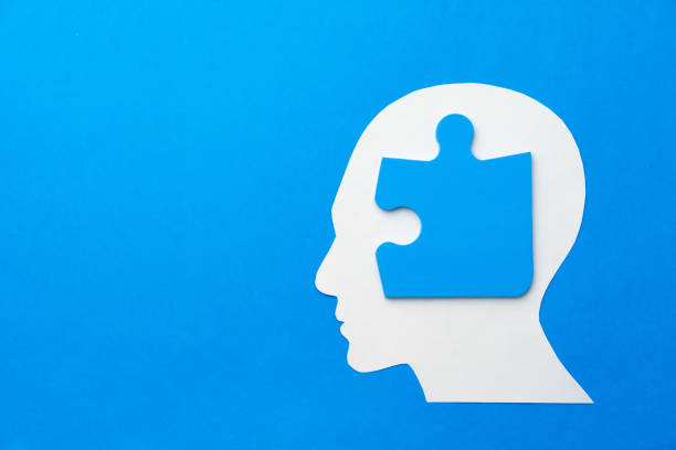istock Papercut head with jigsaw puzzle pieces on blue background 1314464418