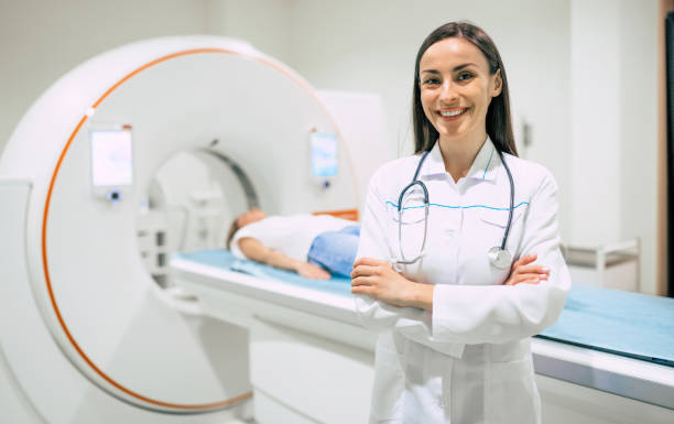 pewna siebie lekarka onkologiczna w rezonansie magnetycznym lub tomografii komputerowej w nowoczesnym szpitalu. - brain surgery mri scanner cat scan oncology zdjęcia i obrazy z banku zdjęć