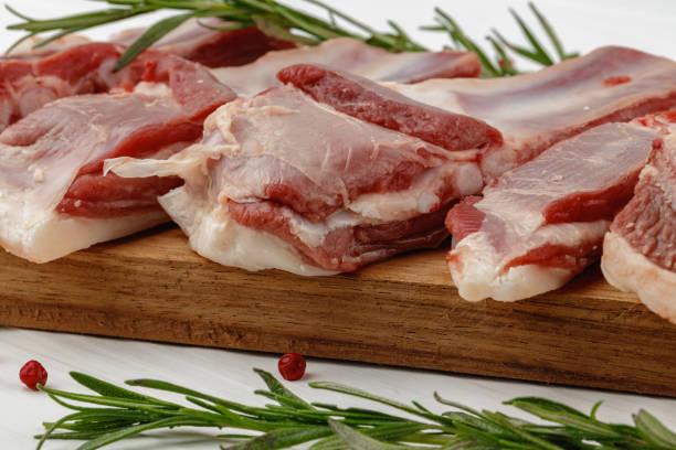 istock Raw meat ribs on wooden board on white background 1314465685