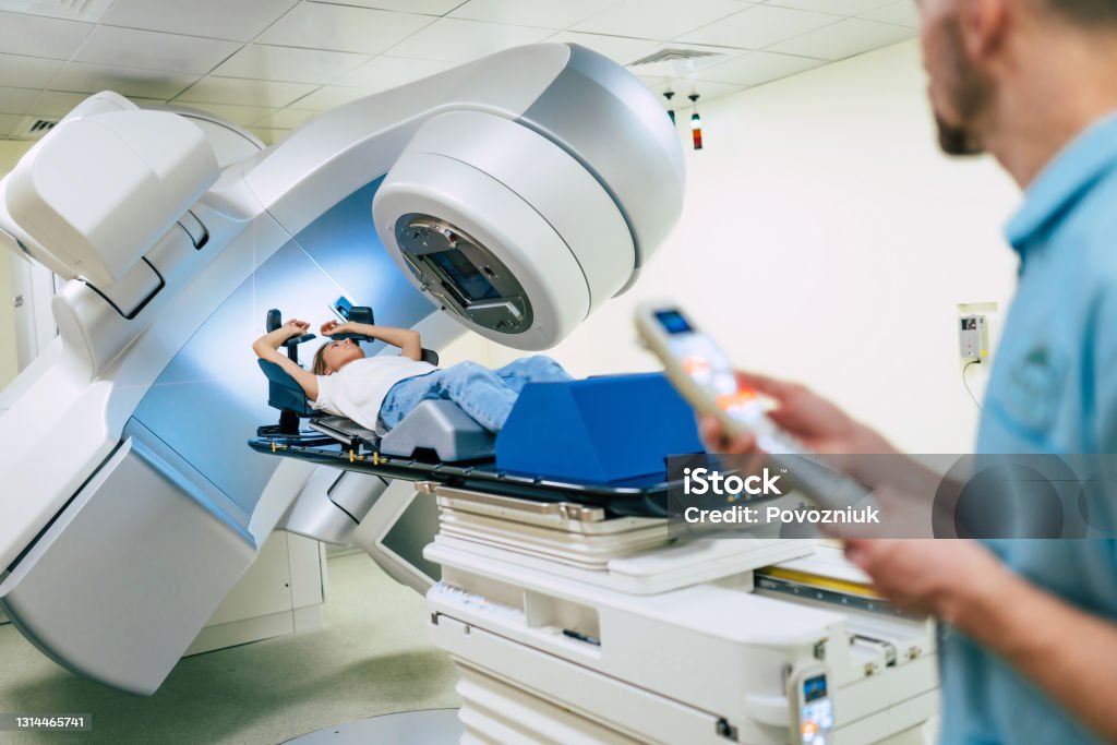 Cancer treatment in a modern medical private clinic or hospital with a linear accelerator. Professional doctors team working while the woman is undergoing radiation therapy for cancer Cancer - Illness Stock Photo