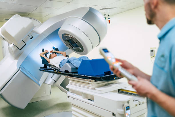 Cancer treatment in a modern medical private clinic or hospital with a linear accelerator. Professional doctors team working while the woman is undergoing radiation therapy for cancer stock photo