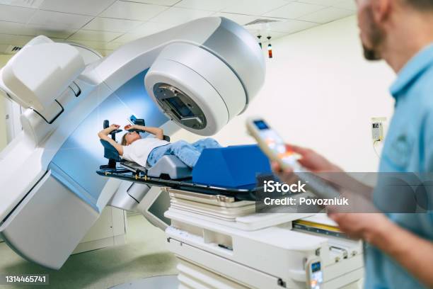 Cancer Treatment In A Modern Medical Private Clinic Or Hospital With A Linear Accelerator Professional Doctors Team Working While The Woman Is Undergoing Radiation Therapy For Cancer Stock Photo - Download Image Now