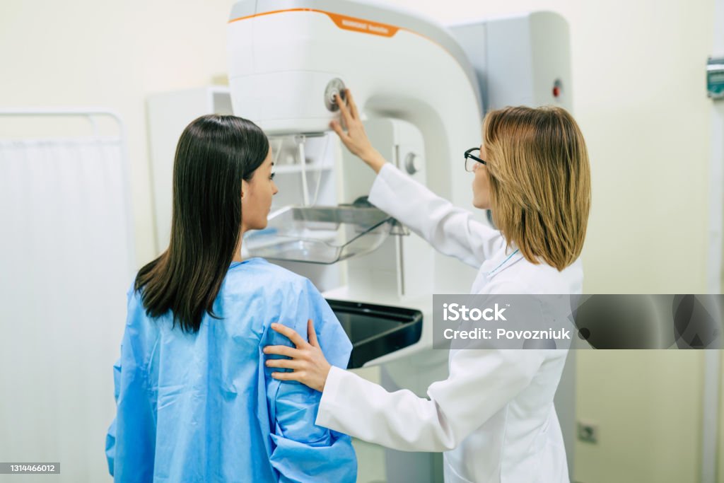 La giovane donna sta facendo un esame di mammografia in ospedale o in clinica privata con una medico professionista. - Foto stock royalty-free di Mammografia