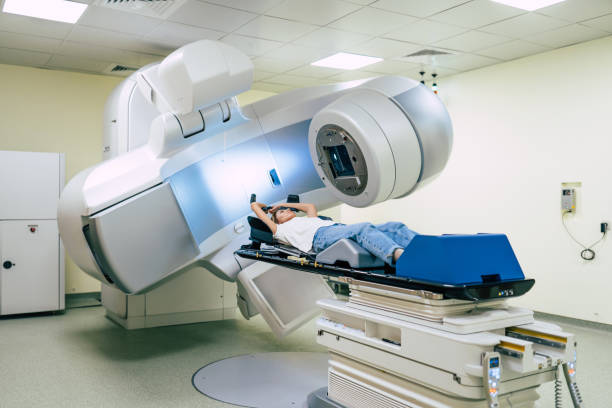 tratamiento oncológico en una clínica privada médica moderna u hospital con un acelerador lineal. equipo médico profesional trabajando mientras la mujer se somete a radioterapia para el cáncer - irradiation fotografías e imágenes de stock