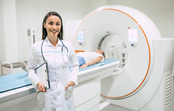 pewna siebie lekarka onkologiczna w rezonansie magnetycznym lub tomografii komputerowej w nowoczesnym szpitalu. - brain surgery mri scanner cat scan oncology zdjęcia i obrazy z banku zdjęć