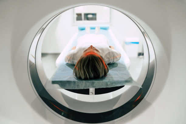 Young woman patient is ready to do magnetic resonance imaging in the modern hospital laboratory stock photo