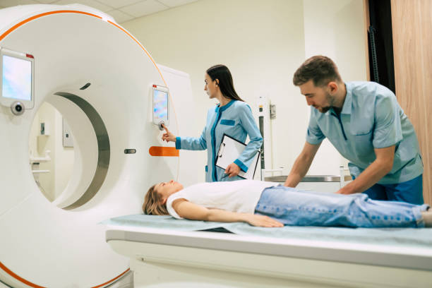 le radiologiste professionnel de docteur dans le laboratoire médical contrôle l’imagerie de résonance magnétique ou la tomographie calculée ou le balayage de pet avec le patient féminin subissant la procédure. - tomographie photos et images de collection