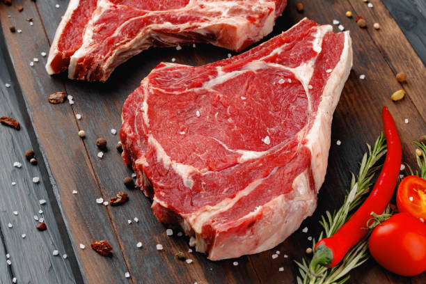 istock Raw rib eye steak on brown wooden board 1314468317