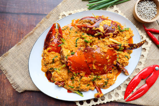 granchio al curry tailandese - famoso granchio saltato in padella con curry in polvere, verdure e uova - cibo tailandese chiamato poo pad pong kari - curry sauces foto e immagini stock