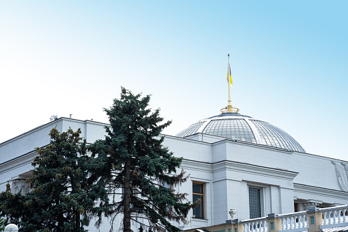 Bandera ucraniana en el asta de la bandera contra un cielo gris. Techo del Parlamento en Kiev. Verkhovna (Verhovna) Edificio Rada del Parlamento ucraniano photo