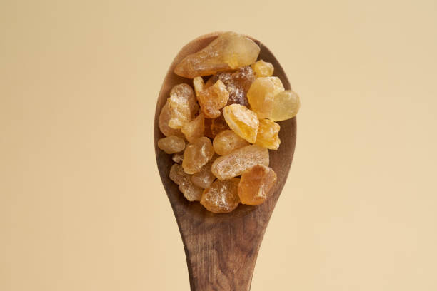 frankincense resin crystals on a spoon on pastel yellow background - tree resin imagens e fotografias de stock