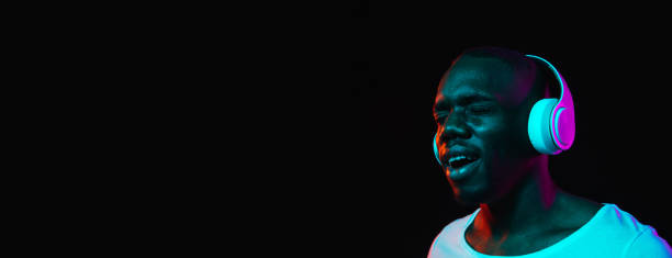 istock Young African-American man isolated on dark background in neon light 1314471216