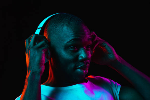 istock Young African-American man isolated on dark background in neon light 1314471231