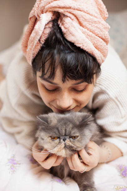 istock Young woman laying in bed with her cat 1314472296