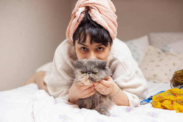 istock Young woman laying in bed with her cat 1314472607