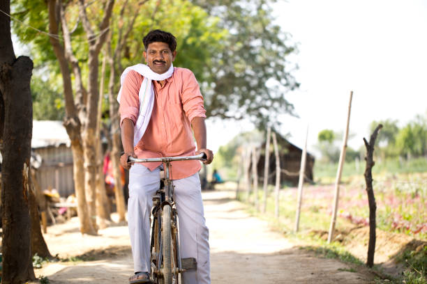 istock Rural man riding bicycle on village road 1314472924