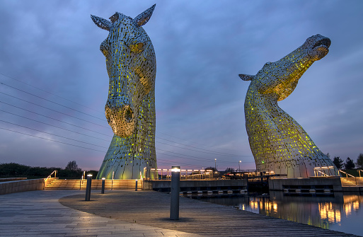 Falkirk, Scotland – April 23, 2021: Opened in 2013, the 30 meter high stainless steel Kelpies made by scuptor Andy Scott are accesible to the public 24 hours a day, allowing visitors to witness them lit up during the hours of darkness.