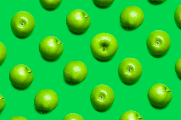 istock Pattern of green apples with green background 1314473631