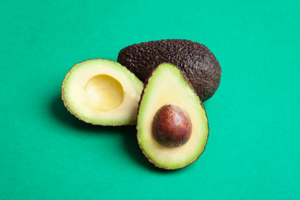 istock halved avocado with green background 1314473678