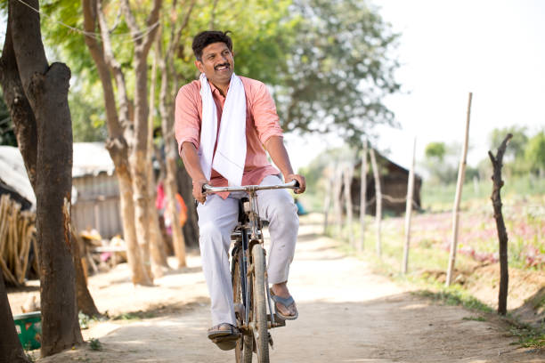 istock Rural man riding bicycle on village road 1314473903