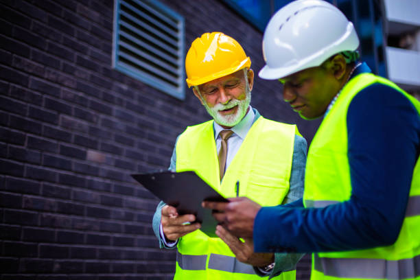 istock Mature engineer discussing the structure of the building with architects colleague at construction site. Reading document. 1314476121