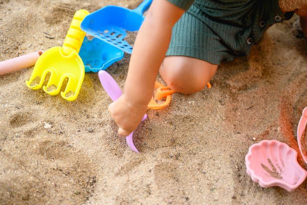 Low section of child playing in the sand, copy space, Nikon Z7