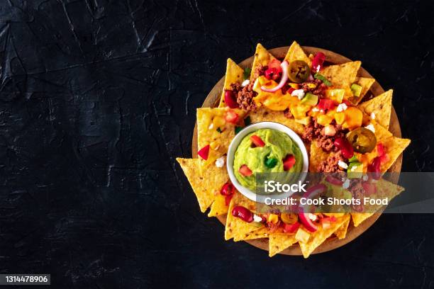 Mexcian Nachos With Beef Cheese Sauce And A Guacamole Dip Shot From Above Stock Photo - Download Image Now