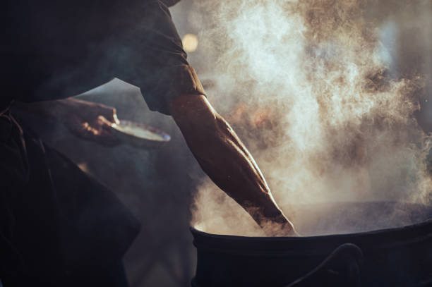 muskularny człowiek ramię sylwetka odkryty street przygotowanie żywności w kocioł żelaza - africa african descent cooking african culture zdjęcia i obrazy z banku zdjęć
