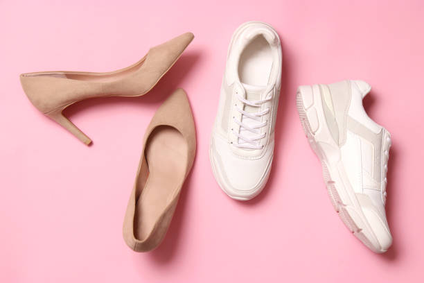istock white sneakers and high heel shoes on a colored background top view. 1314480685