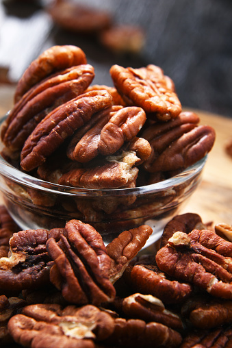 Composition with a bowl of shelled pecan nuts. Delicacies