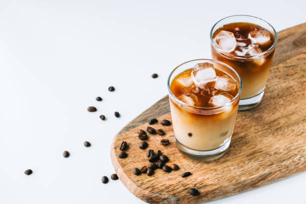 istock Ice coffee in glass with milk and ice cubes, coffee beans on white table... 1314487347