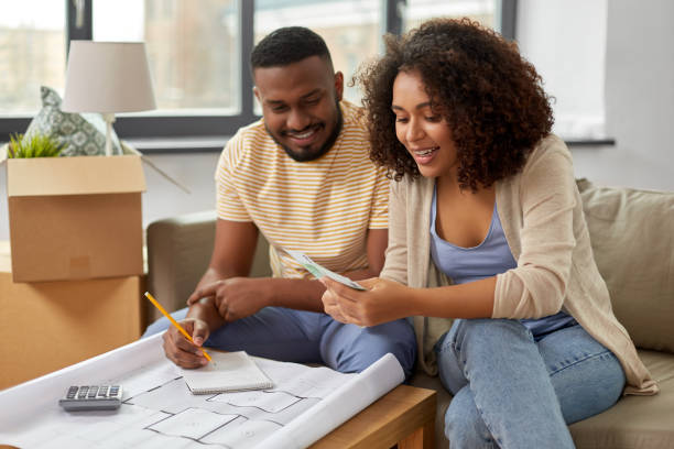 istock couple with blueprint counting money at home 1314488384