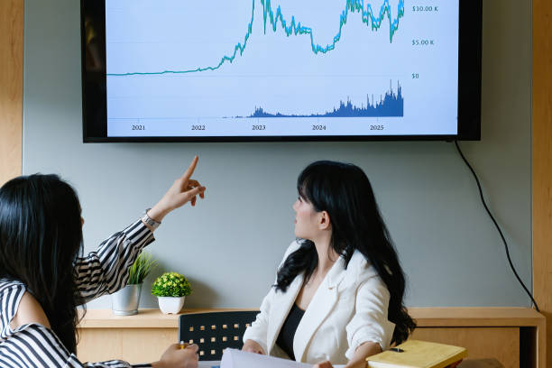 istock Confident young asian woman with partners conducts webinar. Online coach explains fund chart to online audience 1314489687
