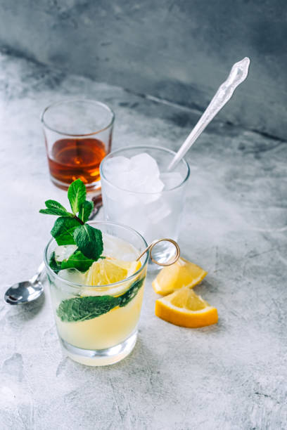 istock Ice lemonade in glass with lemon pieces, fresh mint and ice cubes. 1314490761