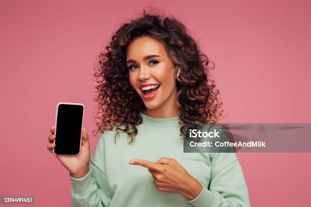 Beautiful Emotional Girl Holding Smart Phone Stock Photo - Download Image Now - Showing, Women, Mobile Phone